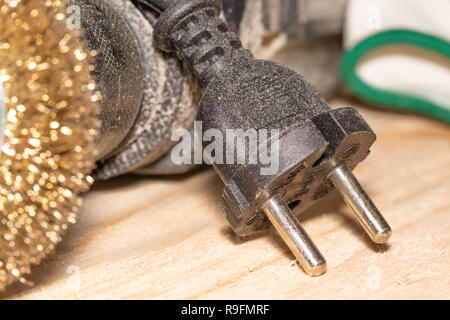 Good old carpentry, woodworking tools. Electric drill with a disc for processing wooden surfaces and gloves on a wooden joinery table after work has b Stock Photo