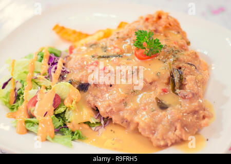 Salted Egg Deep Fried Chicken Chop with fries and salad Stock Photo