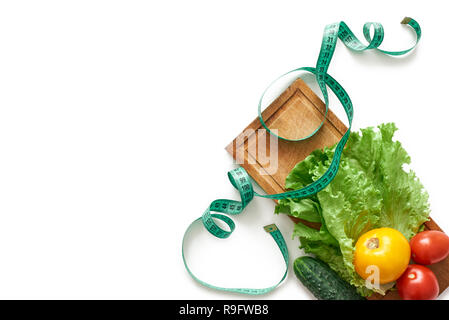 Stay fit. Healthy eating, dieting, slimming and weigh loss concept - close up of vegetables, measuring tape and salad Stock Photo