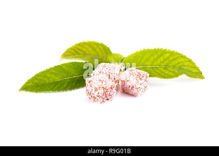 Slices of delicacy Turkish delight with coconut chips and mint leaves isolated on white background Stock Photo