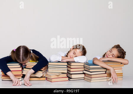 three girls in the classroom are tired of sleeping on books Stock Photo