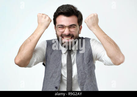 Happy young handsome man gesturing like he has succeed in his job project. Stock Photo
