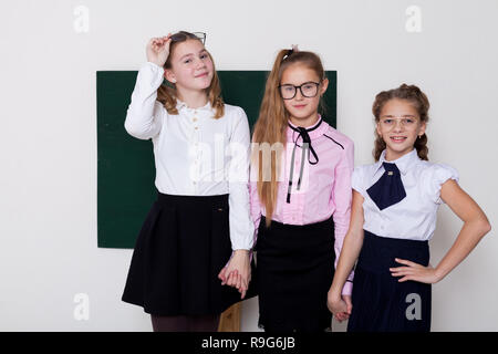 three girls in glasses at the Blackboard in a class lesson Stock Photo