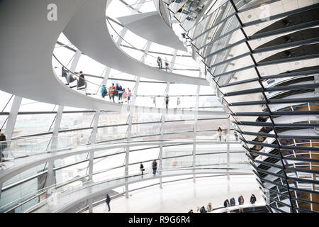 Visitors inside the glass dome on the top of Reichstag Building, a seat of the German Parliament (Deutscher Bundestag) and popular tourist attraction  Stock Photo