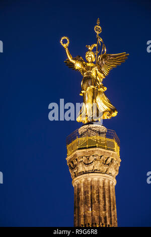 Illuminated golden statue of Victoria on top of the Berlin Victory Column (Siegessaule) monument at night, Tiergarten, Berlin, Germany Stock Photo