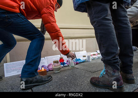 Warsaw, Poland. 23rd Dec, 2018. Protesters are seen lighting candles during the protest. The Nationwide Women's Strike (Ogólnopolski Strajk Kobiet) organized the campaign called 'We accuse pedophiles'. At the gates of churches around Poland, children's shoes were hanged and candles were lightened to commemorate the victims of sexually abused children by Catholic priests. In Warsaw, the action took place in the Old Town's church of St. Anne. Credit: SOPA Images Limited/Alamy Live News Stock Photo