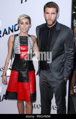 (FILE) Miley Cyrus and Liam Hemsworth appeared to have tied the knot  in a low-key ceremony at home, six years after getting engaged. The singer, 26, and actor, 28, have been seen cutting their wedding cake in a series of photos on social media. Pic taken: LOS ANGELES, CA, USA - AUGUST 08: Singer Miley Cyrus and boyfriend/actor Liam Hemsworth arrive at the Los Angeles Premiere Of Relativity Media's 'Paranoia' held at the Directors Guild of America Theatre on Stock Photo