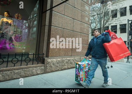 Chicago, USA.  24 December 2018.  A man shops for last minute gifts on Christmas Eve in a chilly downtown on Michigan Avenue's Magnificent Mile. Credit: Stephen Chung / Alamy Live News Stock Photo