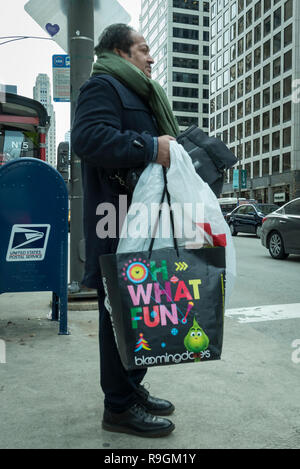 Chicago, USA.  24 December 2018.  A man shops for last minute gifts on Christmas Eve in a chilly downtown on Michigan Avenue's Magnificent Mile. Credit: Stephen Chung / Alamy Live News Stock Photo