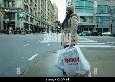Chicago, USA.  24 December 2018.  A woman shops for last minute gifts on Christmas Eve in a chilly downtown on State Street. Credit: Stephen Chung / Alamy Live News Stock Photo