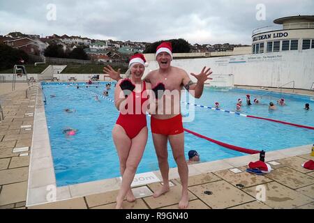 Brighton UK. 25th December 2018 . Mark and Cathy join the  Christmas Day swim at the open air Lido at Saltdean. Brighton. The last  Xmas day swim in newly refurbished pool was  80 years ago. Director Deryck Chester says “this is the start of a new Xmas day tradition and a healthy way to start Christmas Day in an amazing setting”. Caron Watson/Alamy Live News. Stock Photo