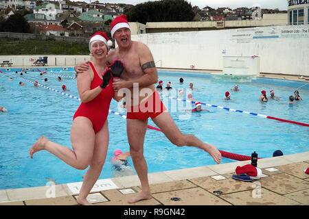 Brighton UK. 25th December 2018 . Mark and Cathy join the  Christmas Day swim at the open air Lido at Saltdean. Brighton. The last  Xmas day swim in newly refurbished pool was  80 years ago. Director Deryck Chester says “this is the start of a new Xmas day tradition and a healthy way to start Christmas Day in an amazing setting”. Caron Watson/Alamy Live News. Stock Photo