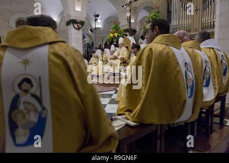 Bethlehem, West Bank, Palestinian Territory. 24th Dec, 2018. Archbishop Pierbattista Pizzaballa, the top Roman Catholic cleric in the Holy Land, center heads a Christmas midnight mass at Saint Catherine's Church, in the Church of the Nativity, traditionally recognized by Christians to be the birthplace of Jesus Christ, in the West Bank city of Bethlehem, on Tuesday, December 25, 2018 Credit: Nasser Nasser/APA Images/ZUMA Wire/Alamy Live News Stock Photo