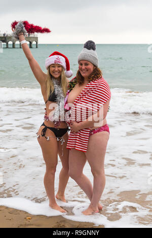 Boscombe, Bournemouth, Dorset, UK. Christmas Day 25th December 2018. Brave volunteers plunge into the cold choppy sea for a swim, for the annual charity White Christmas Dip, dressed in fancy dress costumes and raising money for Macmillan Caring Locally at Christchurch, a Specialist Palliative Care Unit for patients in the local community. Hundreds take part in the event which has become a popular tradition for many before their Christmas lunch. Credit: Carolyn Jenkins/Alamy Live News Stock Photo