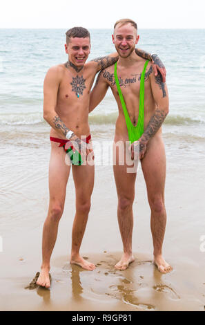 Boscombe, Bournemouth, Dorset, UK. Christmas Day 25th December 2018. Brave volunteers plunge into the cold choppy sea for a swim, for the annual charity White Christmas Dip, dressed in fancy dress costumes and raising money for Macmillan Caring Locally at Christchurch, a Specialist Palliative Care Unit for patients in the local community. Hundreds take part in the event which has become a popular tradition for many before their Christmas lunch. Credit: Carolyn Jenkins/Alamy Live News Stock Photo