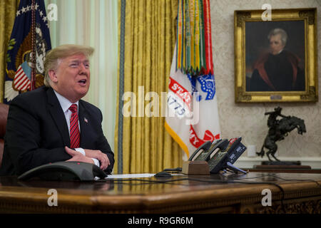Washington, DC, USA. 25th Dec, 2018. United States President Donald J. Trump makes a video call to service members from the Army, Marine Corps, Navy, Air Force, and Coast guard stationed worldwide in the Oval Office at the White House in Washington, DC, U.S., on December 25, 2018. Credit: Zach Gibson/Pool via CNP | usage worldwide Credit: dpa/Alamy Live News Stock Photo