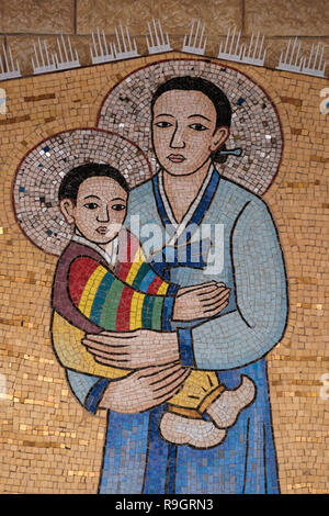 A mosaic painting depicting Mary and the infant Jesus donated by the Catholic community of South Korea in style that boldly reflect the culture of the country and visualize the annunciation in its own local eyes hanging on the wall around the front courtyard of the Roman Catholic Church of the Annunciation or the Basilica of the Annunciation in the city of Nazareth in Galilee northern Israel. Stock Photo