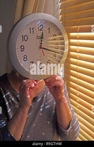 Woman holding a clock face, Daylight Saving Time / British summer Time , clocks going back or forward an hour Stock Photo