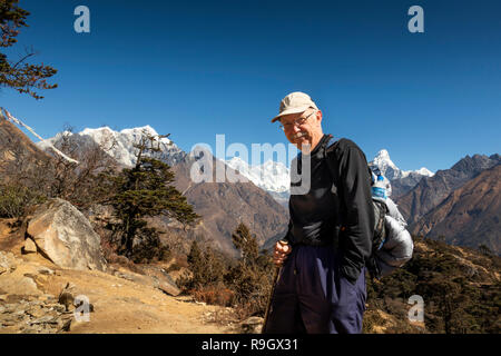 Nepal, Everest Base Camp Trek, older male trekker enjoying view of Mount Everest and surrounding Himalayan mountains Stock Photo