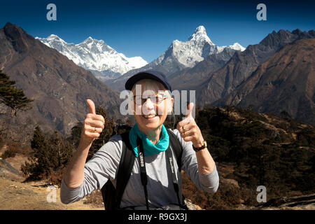 Nepal, Everest Base Camp Trek, senior female trekker giving thumbs up gesture amongst Himalayan mountains Stock Photo