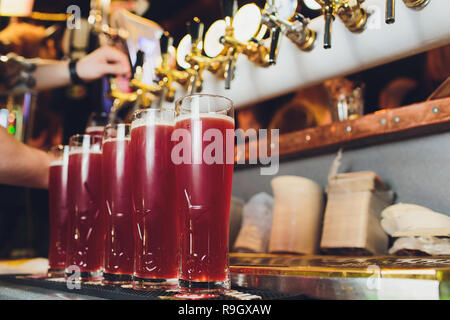 Hand of bartender pouring a red ale from tap. Bar life Stock Photo