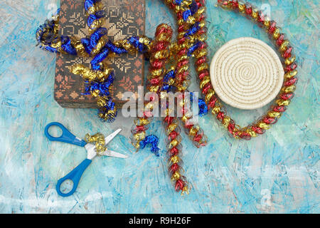 Colorful tinsels, scissors and gift boxes packaging on a table Stock Photo