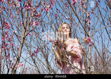 beautiful blonde woman in pink flower garden Stock Photo
