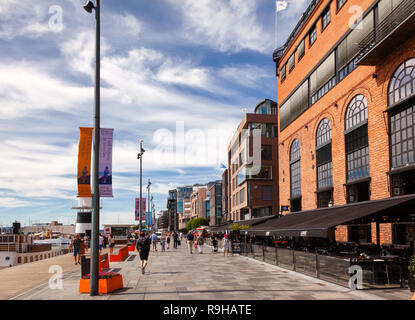 OSLO, NORWAY - JULY 23, 2018: People walking along pedestrian promenade at the Aker Brygge waterfront, a popular tourist attraction in Oslo Stock Photo