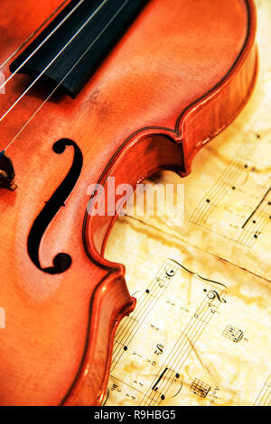 1937 old violin on the background of notes Stock Photo