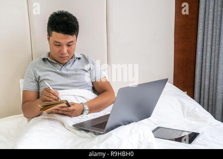 Young Asian businessman writing notebook diary concept Stock Photo