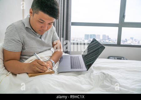 Young Asian businessman writing notebook diary concept Stock Photo