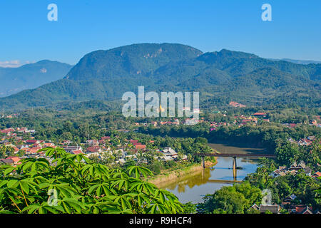A high view from Phou Si Hill Laos across the bridge to the colourful roofs and hills beyond Stock Photo