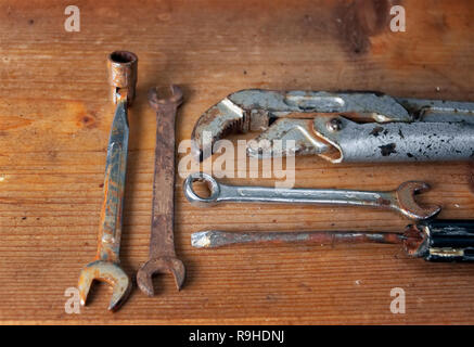 Set of old rusty wrenches laid on the wooden surface Stock Photo