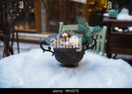 Decorative vintage pot with cones and Christmas toys. Antique vase. Stock Photo