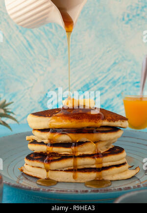 Pancakes stack pouring marple syrup. Little jug. Breakfast. Jem, Papaya. side view Stock photo Stock Photo