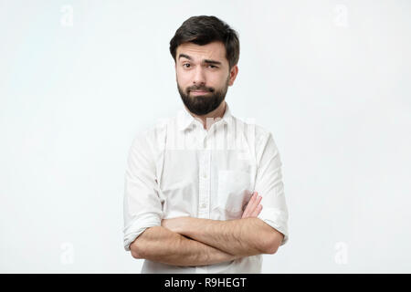 Person lifts his eyebrow and do not really believe in the words he hears, looking gloomy. Stock Photo