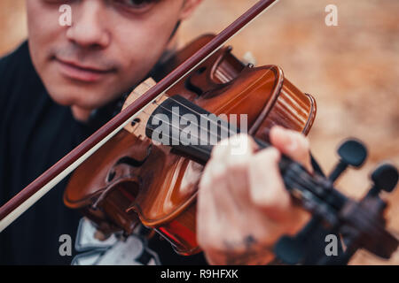 young man playing violin in the autumn forest. Stock Photo