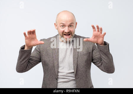 Handsome middle age man wearing suit pretending being a tiger. Stock Photo