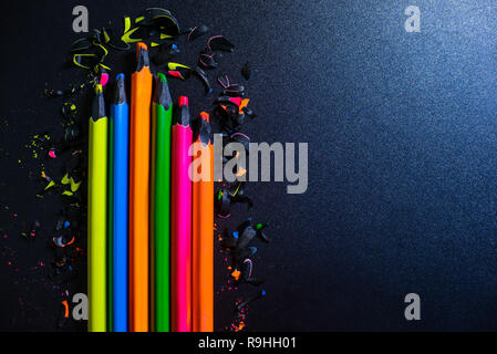 Bright colored abstraction on a dark background. Chips of crayons. Stock Photo