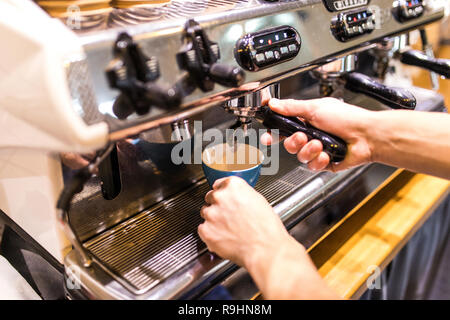 Prepares espresso in his coffee shop with hand and close up Stock Photo