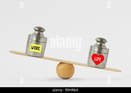 Weights with the words Work and Life written on paper note on balance scale - Concept of life and love priority over work Stock Photo