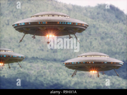 Three unidentified flying objects over a forest with trees and mountains behind. Stock Photo