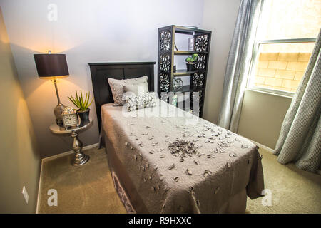 Twin Bed With Pedestal Table, Lamp And Bookcase Stock Photo