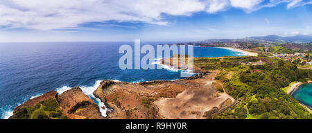 Developed extracted Bombo quarry site in Kiama town - source of hexagonal basalt rocks on pacific coast of Australia in wide aerial panorama. Stock Photo