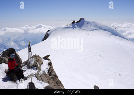backcountry skier and mountain climber on the summit of Zumsteinspitze in the Alps of Switzerland on a winter day Stock Photo