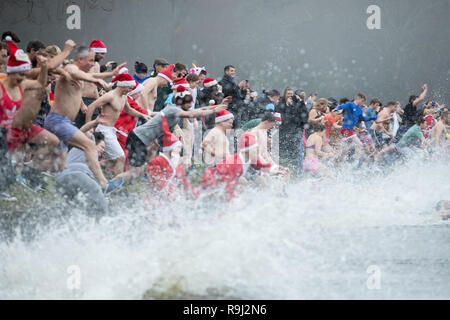 People take a Christmas day swim in Blackroot Pool at Sutton Park in Sutton Coldfield, West Midlands. Stock Photo