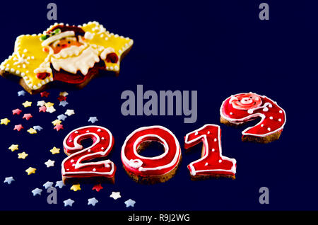 New Year card on blue background gingerbread red numbers 2019 with multi-colored stars and Santa Claus Stock Photo