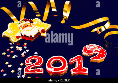 New Year card on blue background gingerbread red numbers 2019 with multi-colored stars and Santa Claus Stock Photo