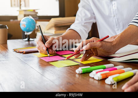 Education concept. Students studying and brainstorming campus concept. Close up of students discussing their subject on books textbooks and writing to Stock Photo