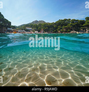 Spain Costa Brava beach in summer and sandy seabed underwater, split view above and below surface, Aiguablava, Begur, Catalonia, Mediterrannean sea Stock Photo